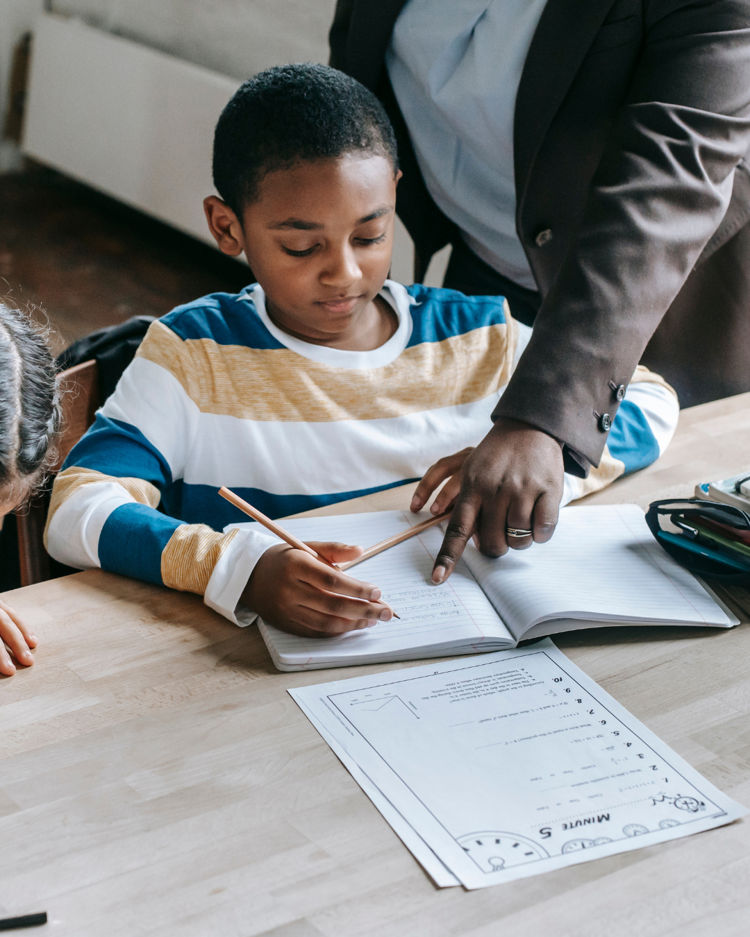 Teacher helping student with workbook