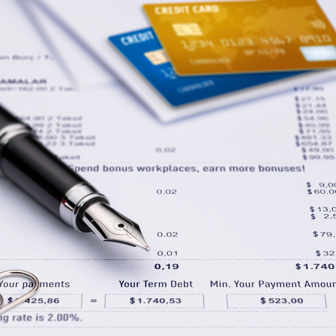 Credit cards and pen on top of a printed bank statement